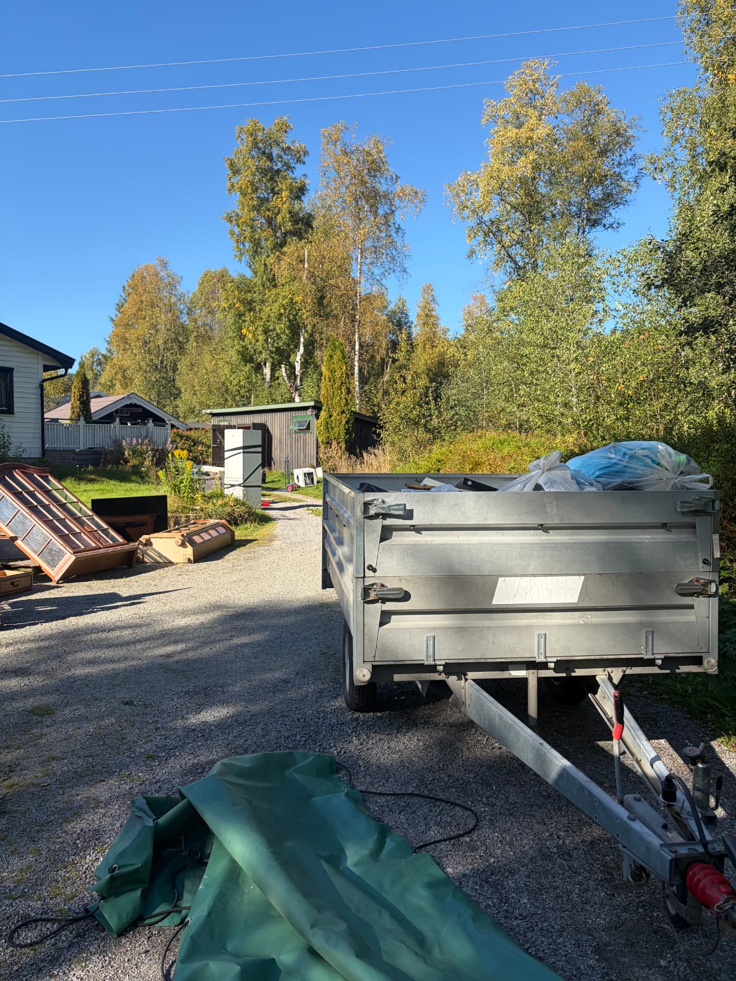Bortkjøring i Eidsvoll – tilhenger med sekker, hvitevarer og møbler klar for gjenvinning